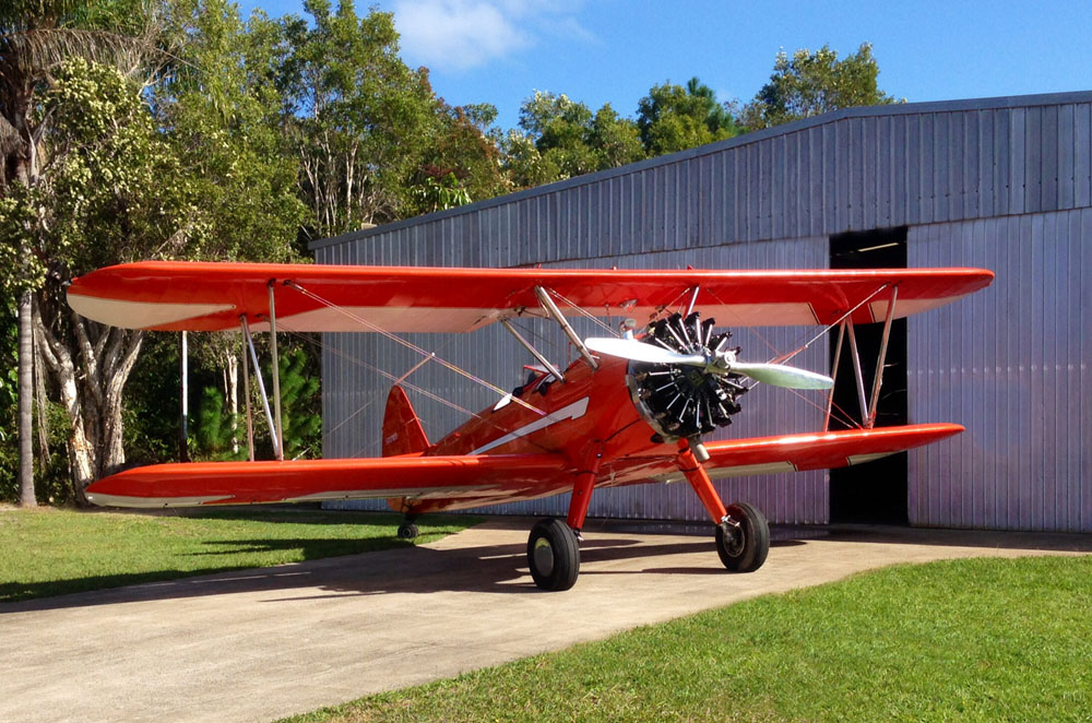 Stearman plane in front of shed