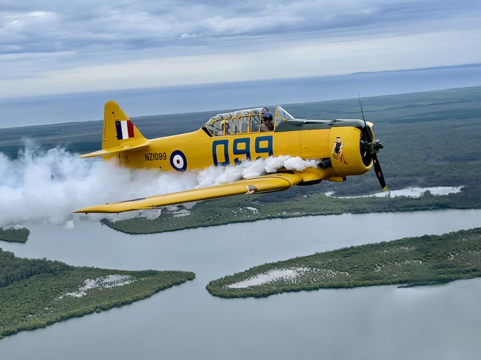 Harvard plane flying billowing smoke from its engine