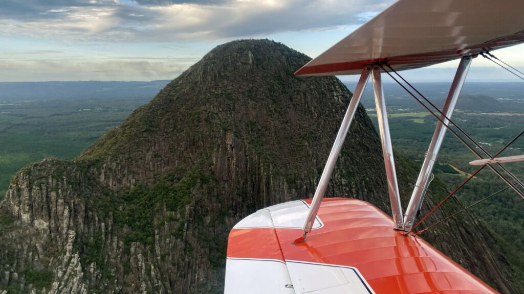 Stearman plane flying over Glasshouse Mountains